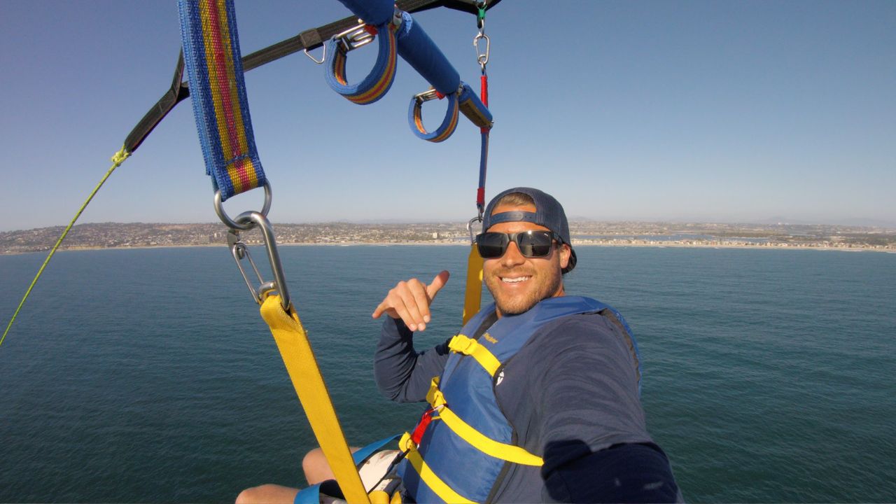 Solo parasailing adventure with ocean and shoreline view below