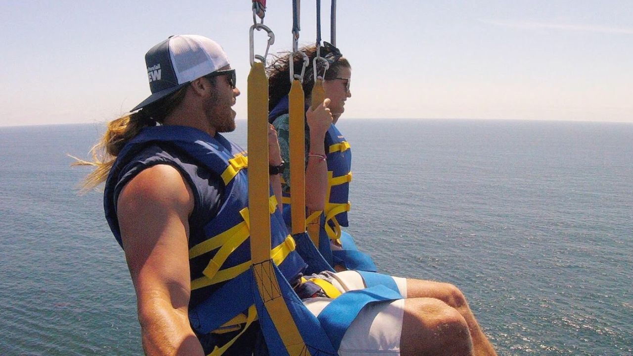 Parasailing adventure selfie with two people flying over open water