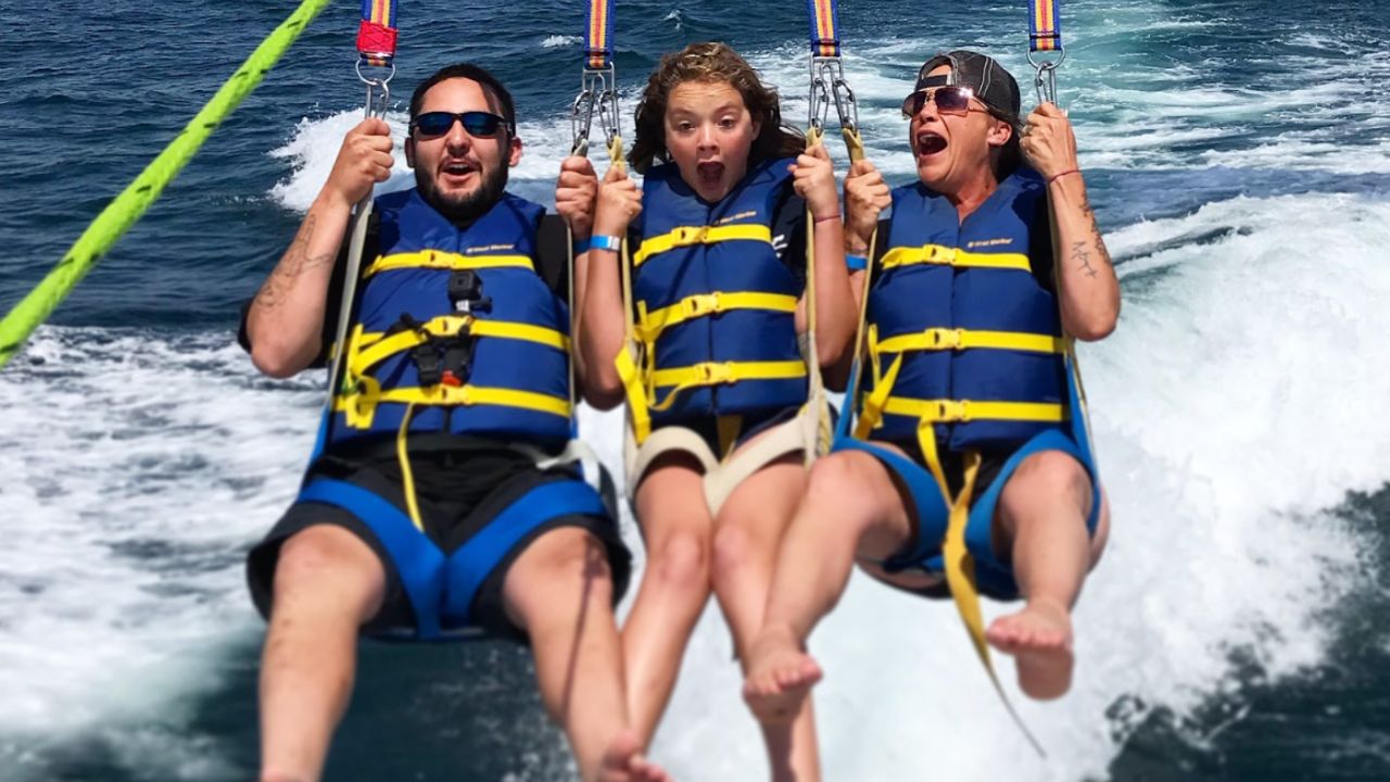 People enjoying tandem parasailing adventure above the Pacific Ocean in San Diego