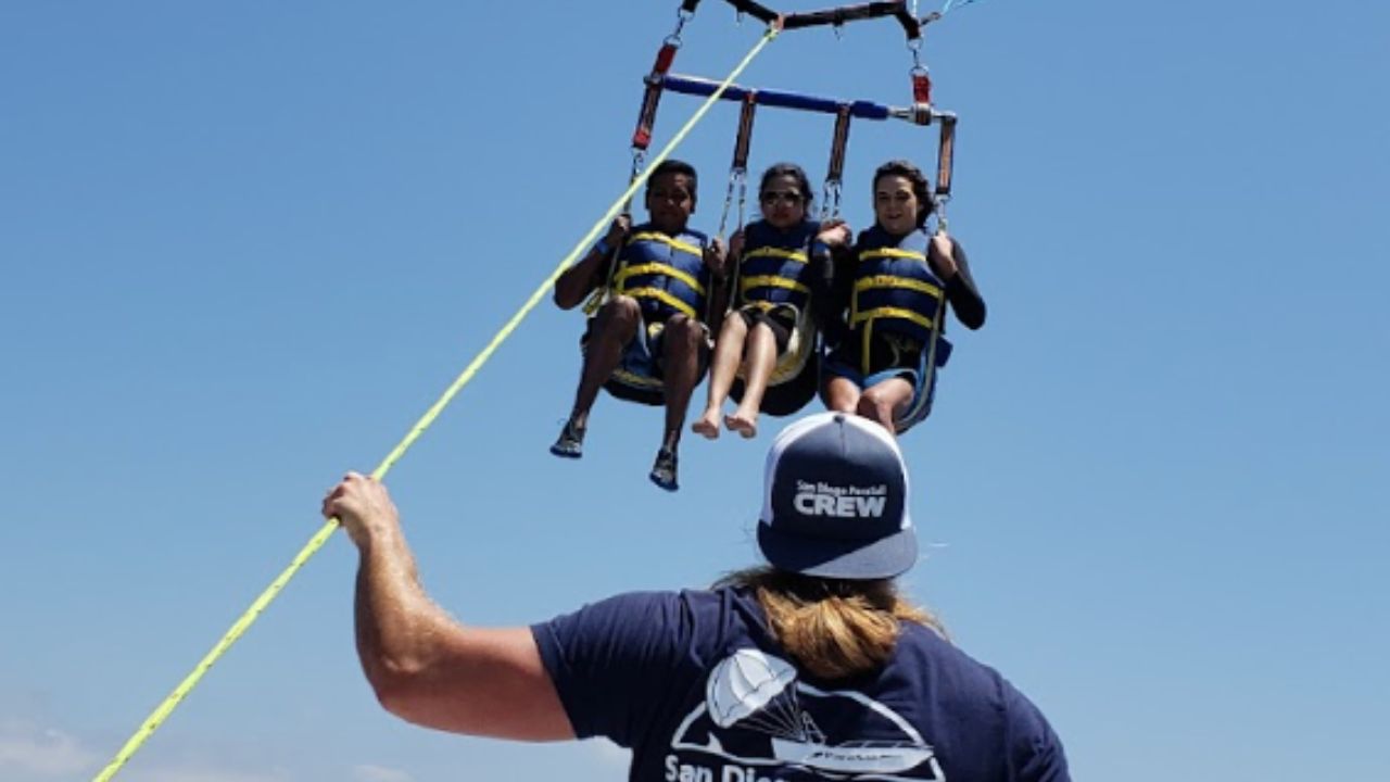 Parasailing crew launching three riders above the ocean during a San Diego parasail tour