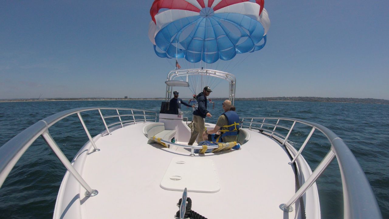 Parasailing crew assisting guests with a safe takeoff from the boat in Mission Bay, San Diego.