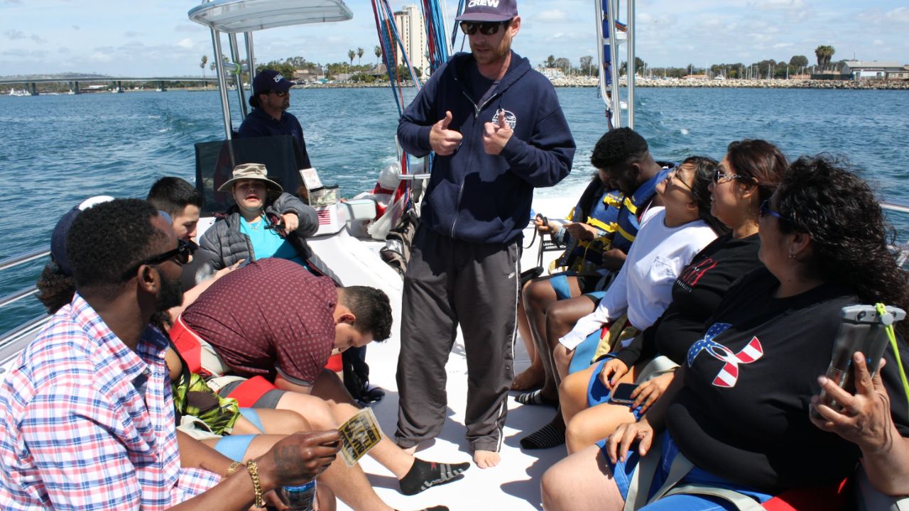 Parasail crew giving a safety briefing to guests before a San Diego parasailing trip.