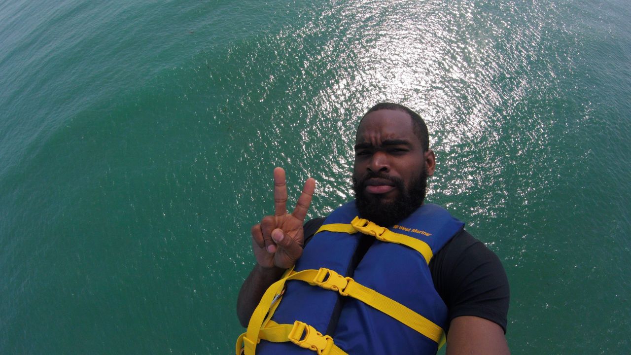 Solo parasailer wearing a life jacket high above the ocean during a parasailing adventure in San Diego.