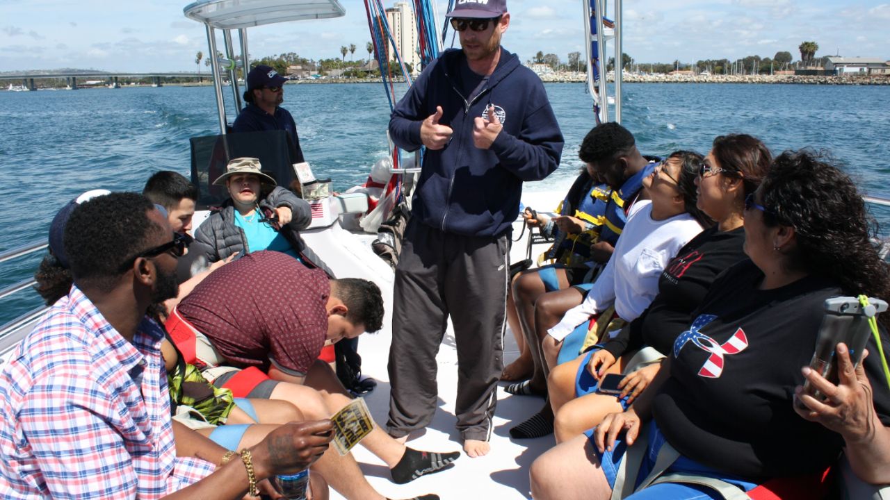 Parasail captain giving a pre-flight safety briefing to guests aboard a parasailing boat before departure in San Diego.