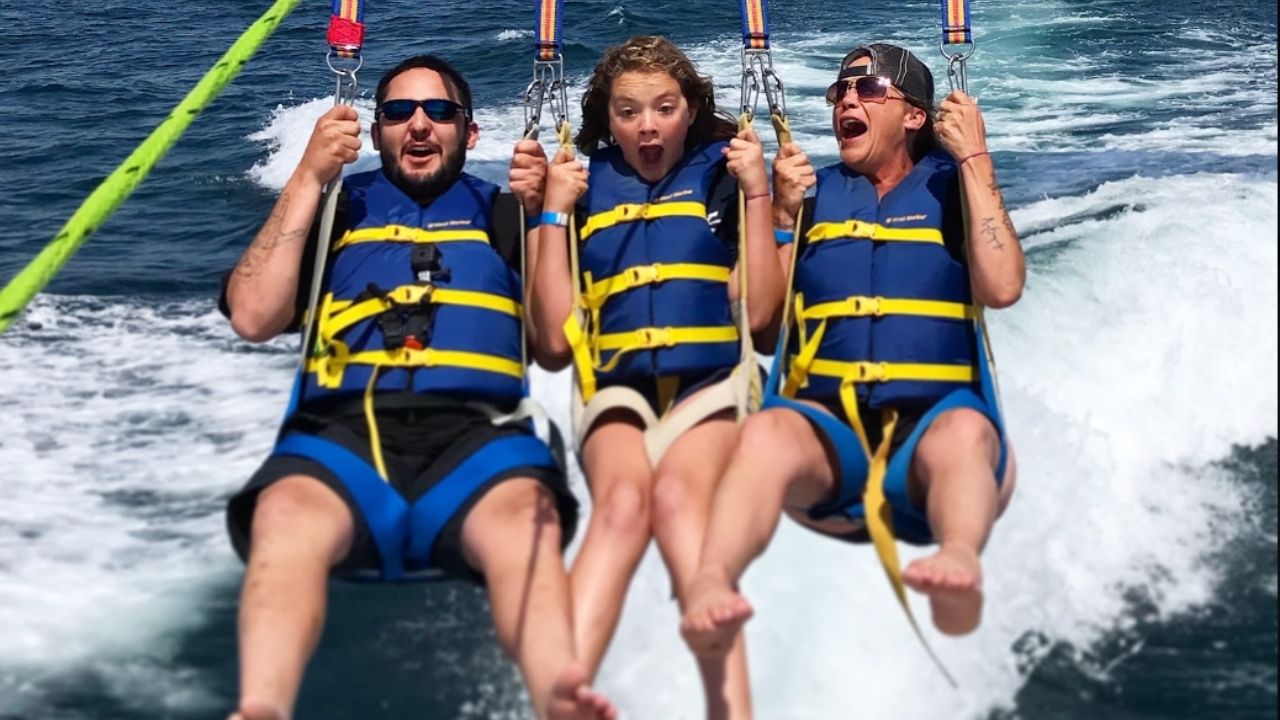 Three guests enjoying an exciting parasailing experience over San Diego waters. 