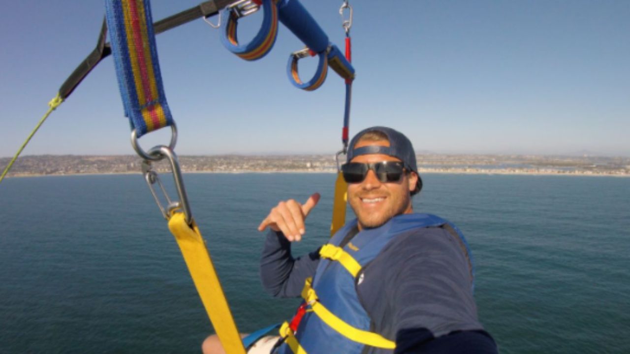 Parasailer flying over the ocean with harness gear