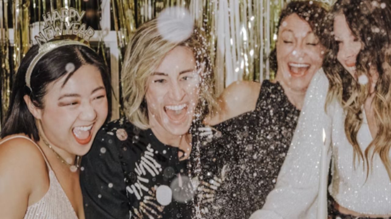 A group of women popping champagne.