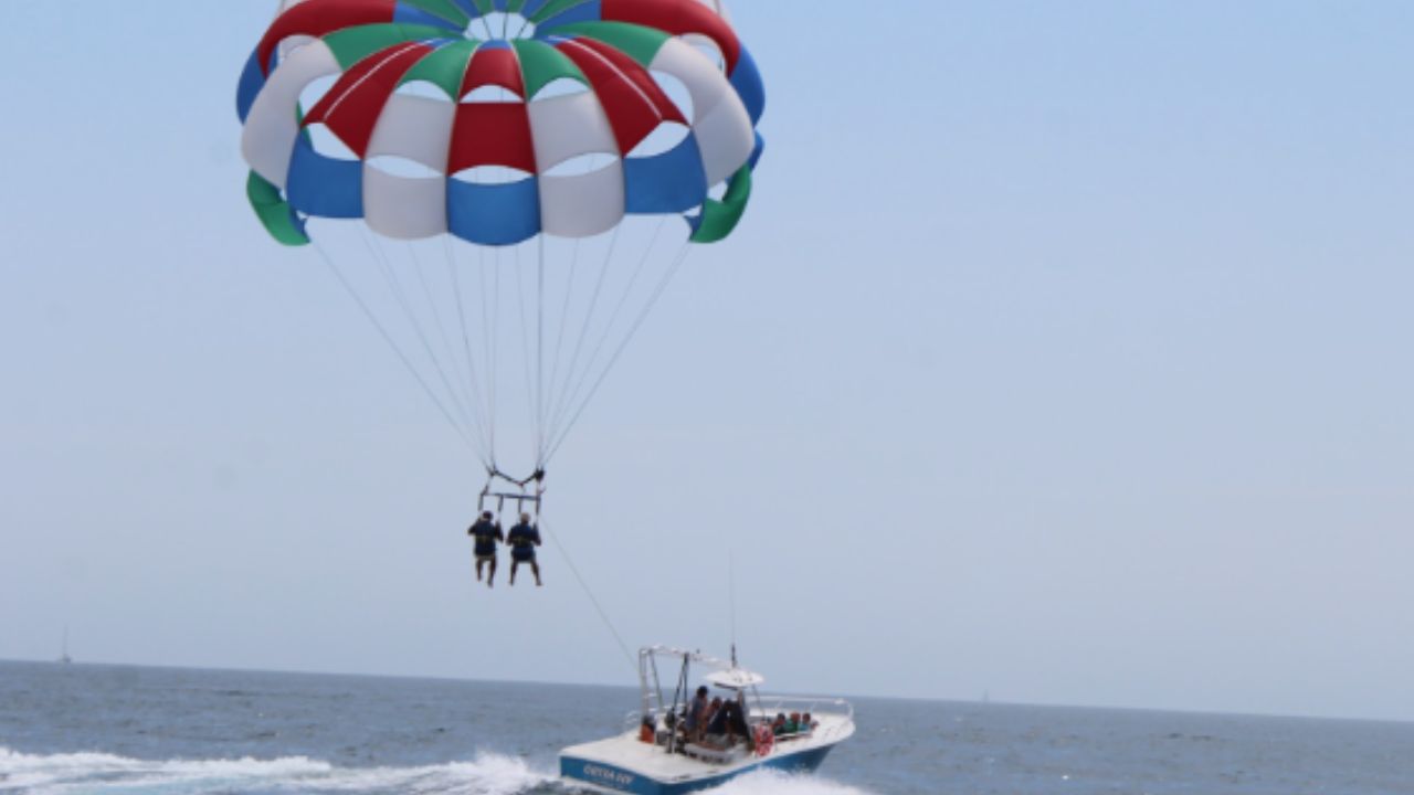 2 people enjoying parasailing above the ocean.